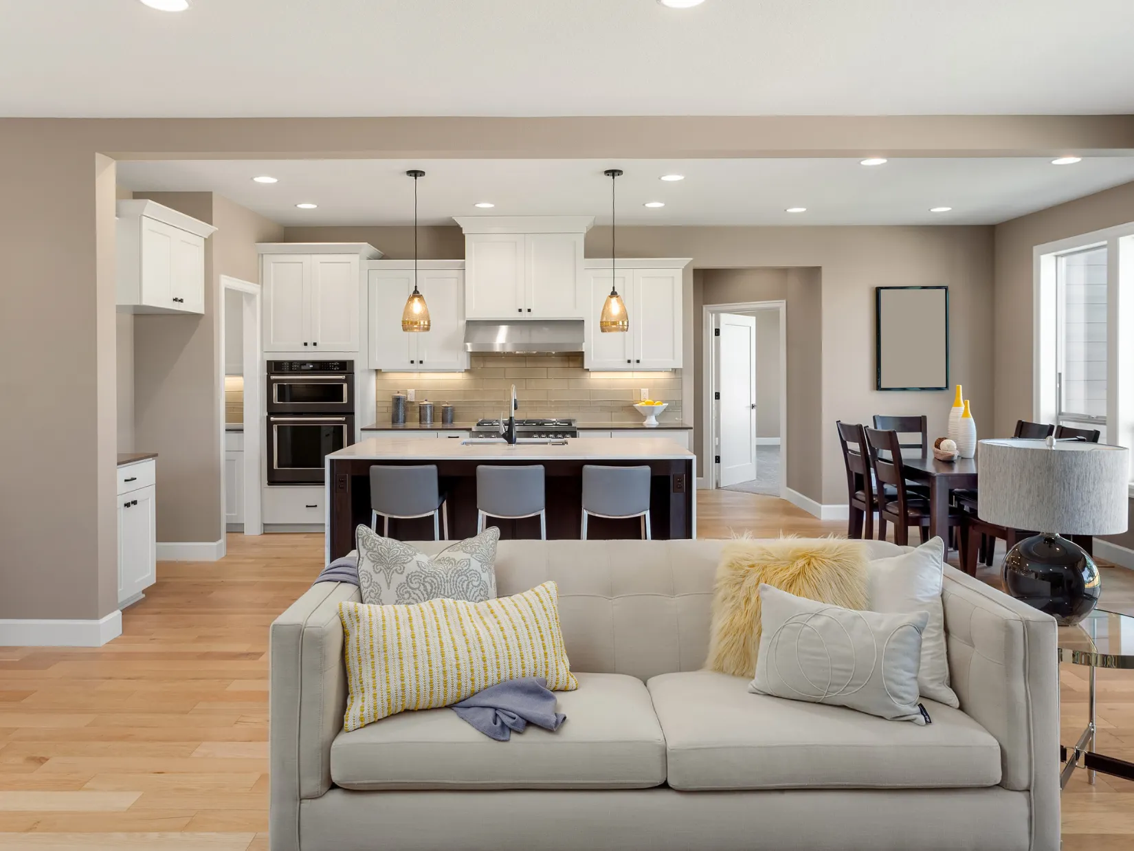 Open concept kitchen remodeling in Dallas TX featuring professional wall removal to integrate the living room with a modern white kitchen, large island seating, and seamless open living design.